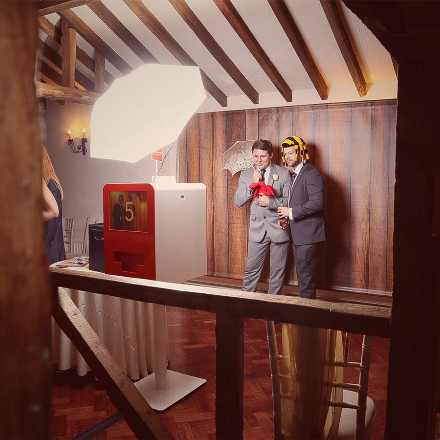 Photo booth at wedding with wooden backdrop